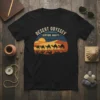Desert Odyssey Venture Awaits text with a camel caravan silhouette against a sunset landscape on a black t-shirt