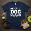 Navy blue t-shirt with bold white text reading "DOG COACH" and graphics of a dog jumping through a hoop, a