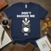 Don't Badger Me t-shirt with a grumpy badger wearing glasses and arms crossed. The text "DON'T BADGER ME" is in