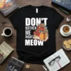 Black t-shirt with white text "DON'T BOTHER ME RIGHT MEOW" and a cartoon cat reading a book, surrounded by books