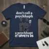 T-shirt with white text "don't call a psychhaph a psychhapt IT UPPETS US" and graphic of two figures, one holding