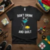 Black t-shirt with white text "DON'T DRINK AND QUILT" above a martini glass filled with blue liquid, surrounded by sewing