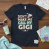 Don't Make Me Call My Gigi text design on a navy t-shirt with pastel gradient lettering and a vintage cell