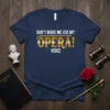 Navy blue t-shirt with white text "DON'T MAKE ME USE MY" and "VOICE", and bold gold text "OPERA!" in between