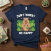 Don't Worry Be Cappy quote with a cute capybara wearing a flower crown holding tea and a book