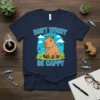 Cute capybara wearing a crown with birds on its head, text reads "DON'T WORRY BE CAPPY" on a navy t-shirt