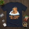 Don't Worry Be Capy t-shirt design with a capybara wearing headphones and playing video games on a cloud