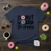 Donut Worry Be Happy text design on a navy t-shirt, featuring two donuts and playful typography
