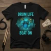 Drum Life Beat On text with a graphic of a drum kit and heartbeat line on a black t-shirt