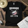 Black t-shirt with "DRUMMER EST. 1776" text and a vintage drum graphic featuring the American flag