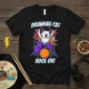 Drumming Cat Rock On! text with a white cat playing a drum set graphic, vibrant colors, on a black t-shirt