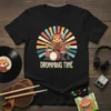 Drumming Time t-shirt design with a cute red panda playing a drum set, vintage sunset background