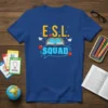 Blue t-shirt featuring "E.S.L. SQUAD" text with open book, apples, and paper airplanes graphic