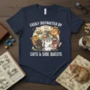 Easily Distracted By Cats & Side Quests text with cartoon cats dressed as adventurers, on a navy t-shirt