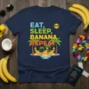 Eat Sleep Banana Repeat t-shirt design with three smiling bananas on a tropical island, palm trees, and colorful text