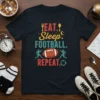 Eat Sleep Football Repeat text design with football graphic on a navy t-shirt