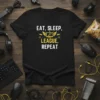 Eat Sleep League Repeat text with computer monitor graphic on a black gamer t-shirt
