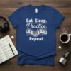 Eat Sleep Practice Repeat text with a piano keyboard graphic and musical notes on a navy blue t-shirt