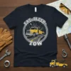 Eat Sleep Tow text with a yellow tow truck and city skyline graphic on a navy t-shirt