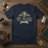 El Cubb vintage pub logo t-shirt with lion emblem and decorative banner, navy blue tee design