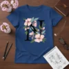 Letter N floral design with pink flowers and green leaves on a navy blue t-shirt