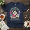 Navy t-shirt featuring "Elegant Tea & Garden Whispers" quote with a floral wreath, teapot, and hummingbirds