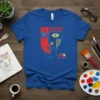 ENARRA abstract face t-shirt with geometric design in red, blue, yellow, and black on a royal blue tee