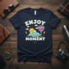 Enjoy Every Moment t-shirt with a cheerful sun, mountains, and hot air balloon graphic