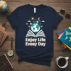 Enjoy Life Every Day quote on a navy t-shirt with a graphic of people holding hands around a globe above