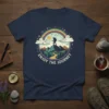 Enjoy The Journey t-shirt with a hiker on a mountain peak under a rainbow, featuring nature-inspired graphics and text
