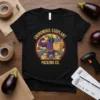 Enoromous Eggplant Packing Co. t-shirt design featuring a muscular eggplant character on a packing conveyor belt