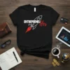 Black t-shirt with "ENTREPRENEU Her" text and a stylized rocket graphic in white and red