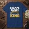Escape Room Birthday King text design with a graphic key, on a navy blue t-shirt