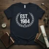 EST. 1984 design on a navy t-shirt with a white laurel wreath and mountain emblem