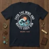 Even The Wind And Waves Obey Him t-shirt with a circular design of a sailboat on a wavy ocean under