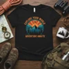 Black t-shirt with "Explore Your World Adventure Awaits" text and mountain sunset graphic, featuring compass rose and pine trees