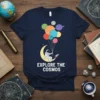 Explore The Cosmos text with astronaut on moon holding planet balloons, space graphic tee design