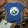Explore The Summit Conquer The Peak t-shirt with a circular graphic of a hiker on a mountain peak and evergreen