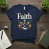 Navy t-shirt with the word "Faith" in gold, a blue glowing cross on a mountain path, and surrounding floral graphics