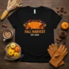 Black t-shirt with "FALL HARVEST EST. 2023" text and a central pumpkin surrounded by autumn leaves and flowers