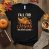Black t-shirt with "Fall For Jesus He Never Leaves" text, cornucopia, pumpkins, and autumn leaves graphic
