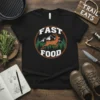 Black t-shirt with "FAST FOOD" text above and below a running deer graphic with mountains and pine trees, circular design