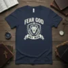 Fear God Not Man t-shirt with a shield, lion head, and cross graphic in cream text on a navy shirt