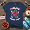 Feeling Berry Good text with a happy, retro strawberry character on a navy t-shirt design