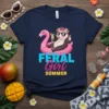 Feral Girl Summer t-shirt design with an opossum on a flamingo float, wearing sunglasses and holding a drink