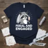 Feral and Engaged t-shirt with a cartoon raccoon bride wearing a tiara and veil, holding a champagne flute