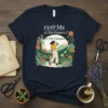 Find Me in the Flowers in the Flowers quote t-shirt with a woman walking through a floral landscape