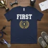 Navy blue t-shirt with the word FIRST in white block letters and a gold laurel wreath with an upward arrow