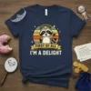 Raccoon wearing a crown on a t-shirt with text "FIRST OF ALL I'M A DELIGHT" and retro sunset background