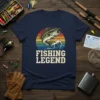 Fishing Legend t-shirt design featuring a jumping bass fish over waves and a retro sunset, with bold white text below